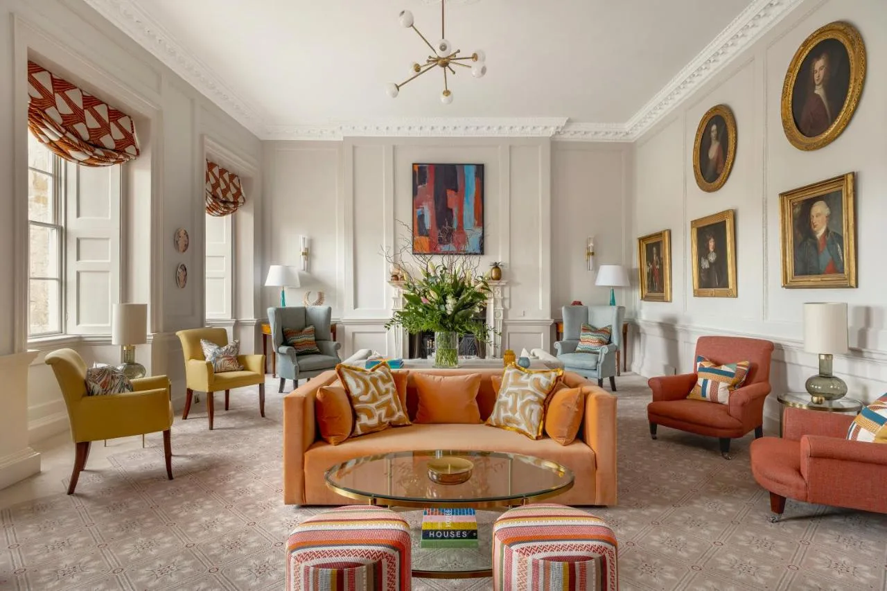 A living room with an orange couch and chairs at the Royal Crescent Hotel & Spa